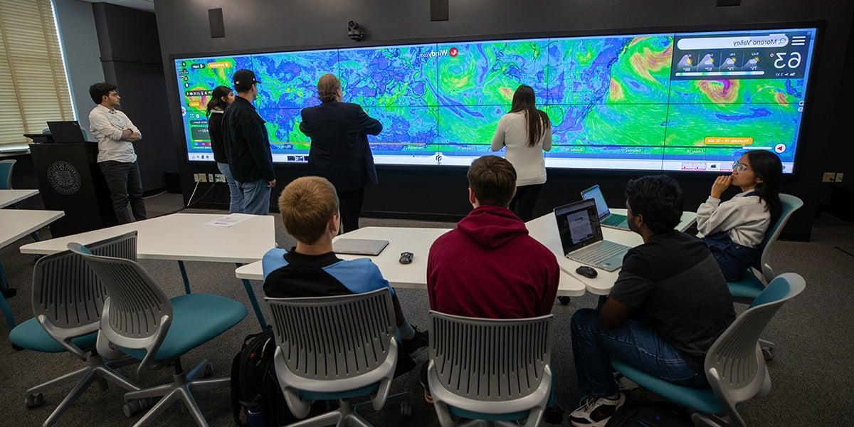 Students in a classroom with a large widescreen display